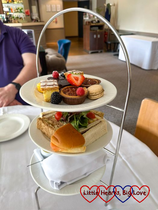 An afternoon tea cake stand with sandwiches, cakes and scones