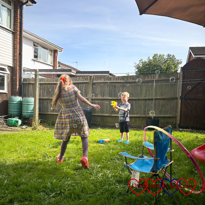 Sophie and Thomas having a water fight in the garden
