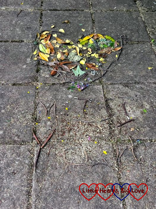 A heart made from leaves with the words 'Miss you' made from twigs